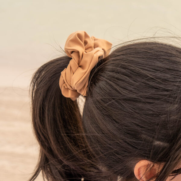 Model showcasing the scrunchies in beige