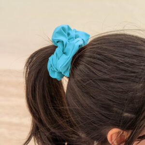 Model showcasing the scrunchies in cyan